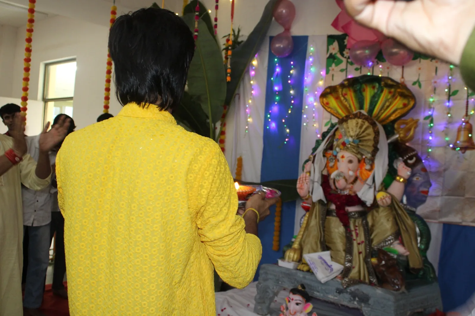 Student in yellow offering prayers at a campus celebration